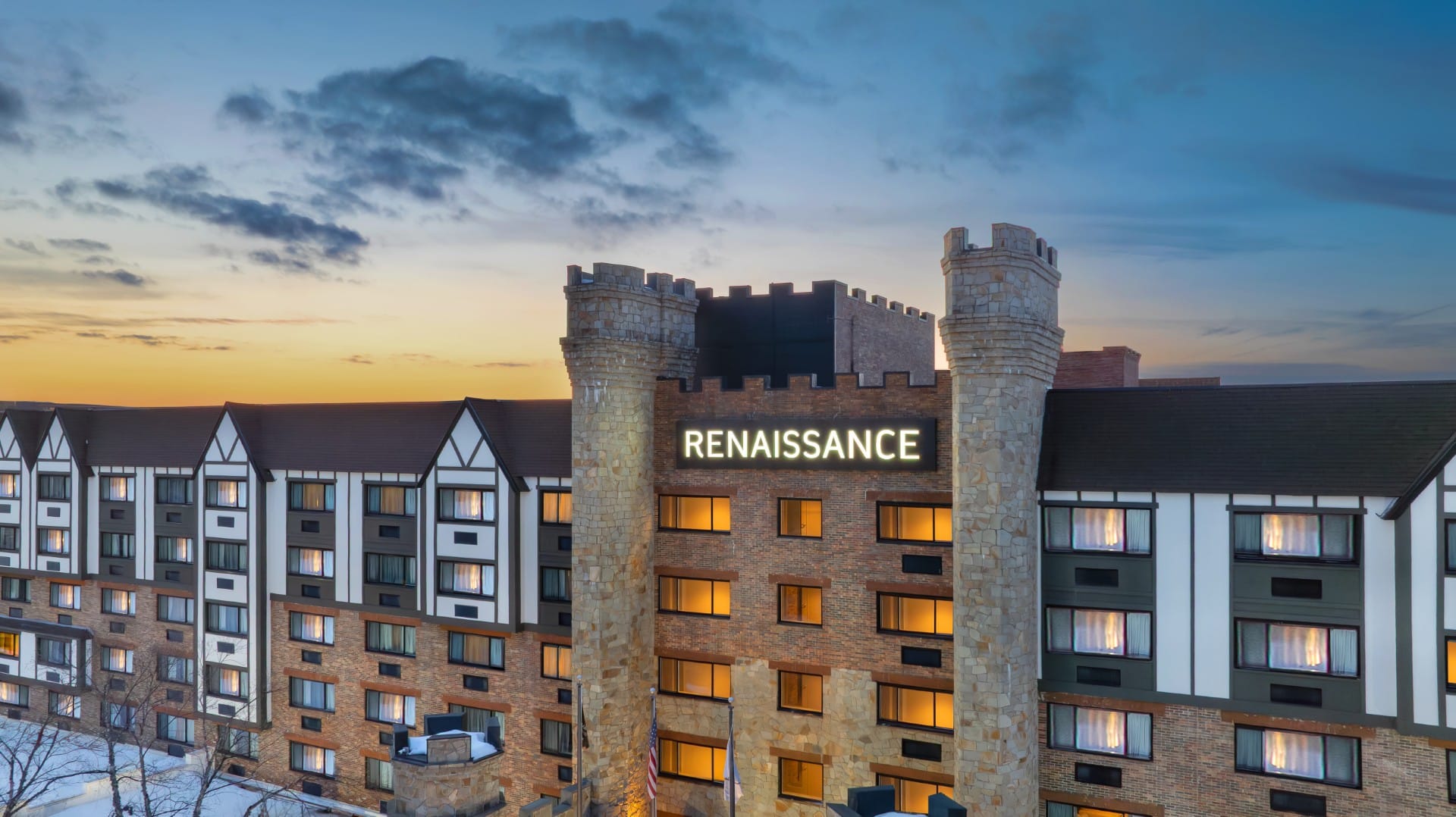 Evening view of the renovated castle-style Renaissance Framingham Hotel with warmly lit entrance