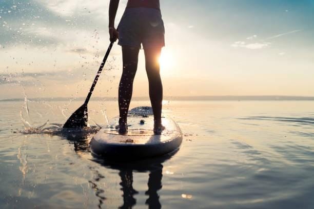 summer sunset lake paddleboarding detail summer sunset SUP rear view part of woman paddling with stand up paddle board alone in lake paddleboard stock pictures, royalty-free photos & images