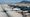 Aerial view of Athens International Airport in 2025 with planes, terminal, and Mount Hymettus in background