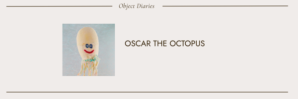Oscar the Octopus; a happy octopus stuffed animal with a red smile and blue eyes