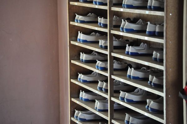 A rack of bowling shoes in order.