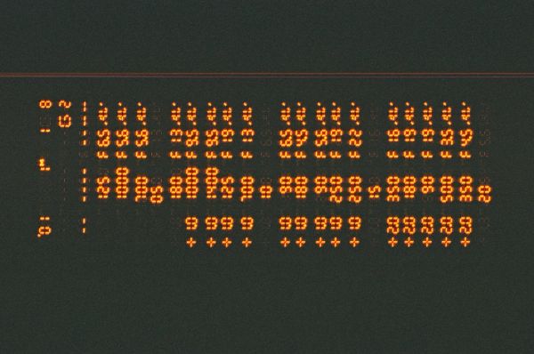 Old orange segment screen displaying a lot of numbers in a table.
