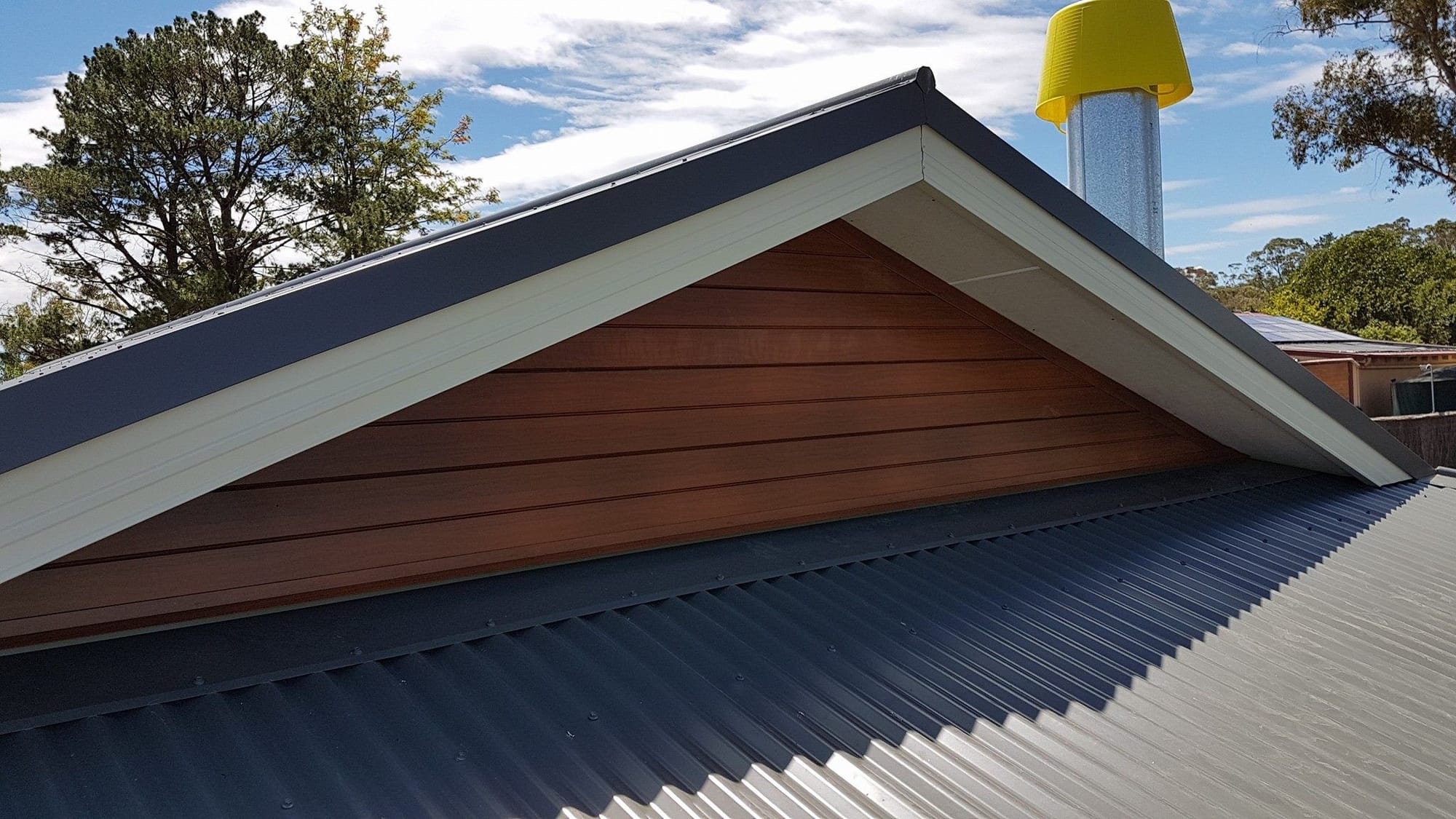 A metal roof with a dutch gable and verge overhang