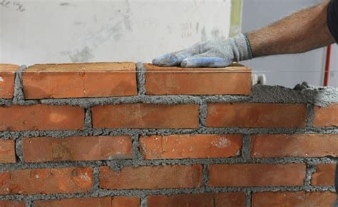 Man laying a brick wall