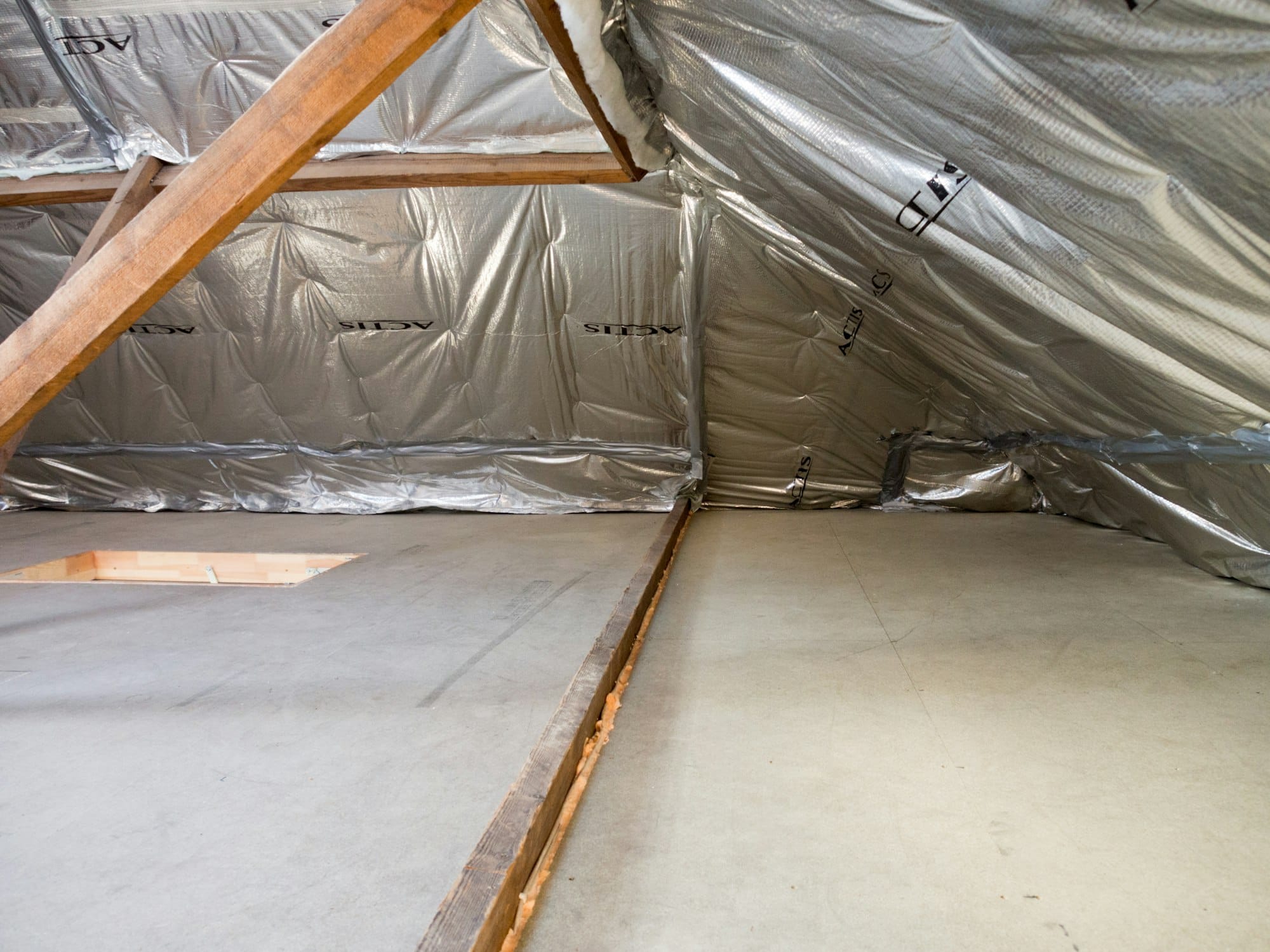 Inside of an attic with insulation and wood beams