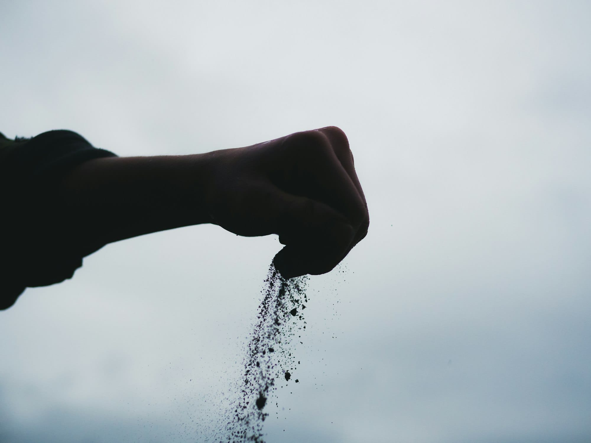 A hand is sprinkling water from a sprinkler