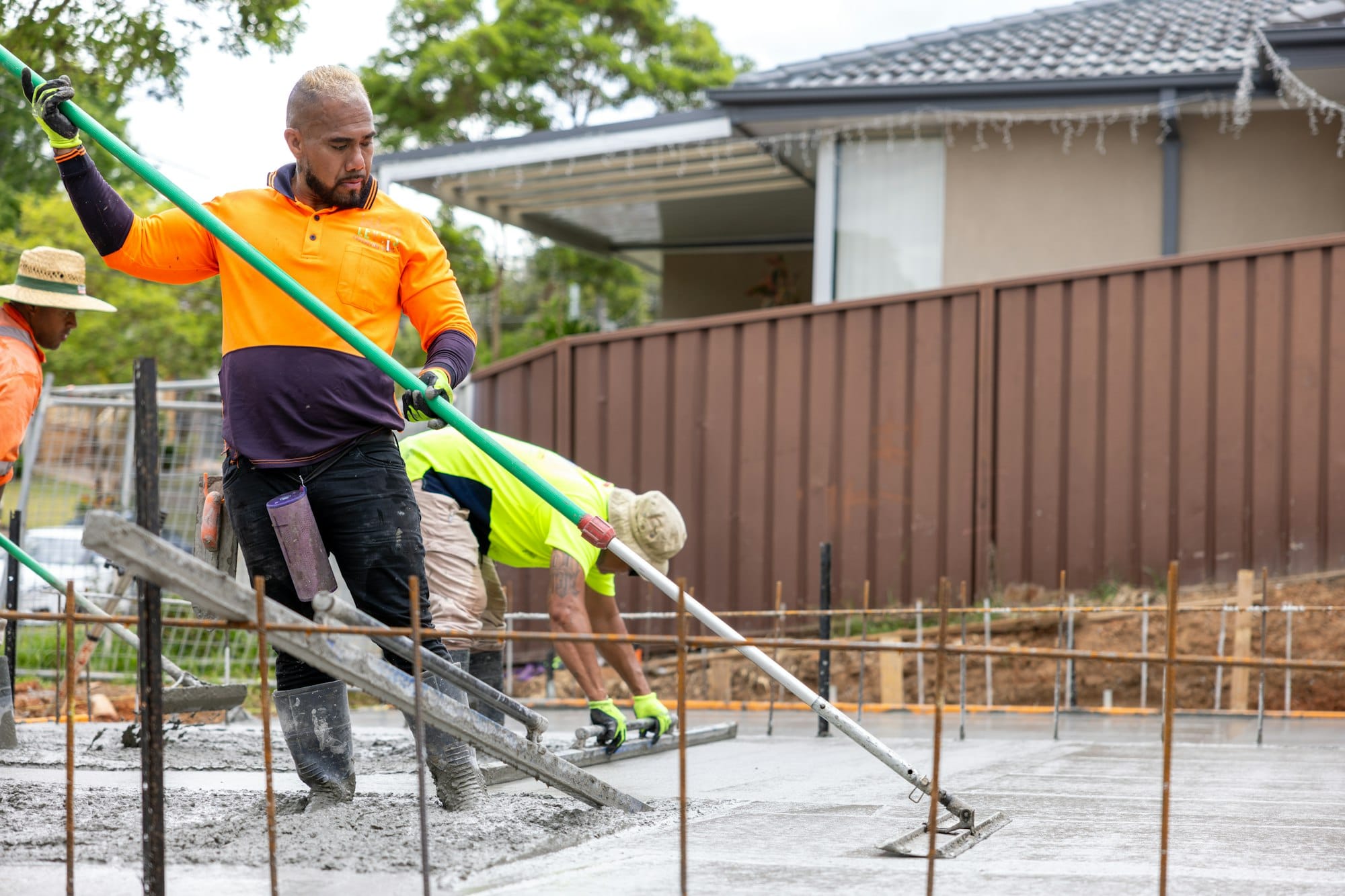 Construction workers are smoothing concrete on a new slab