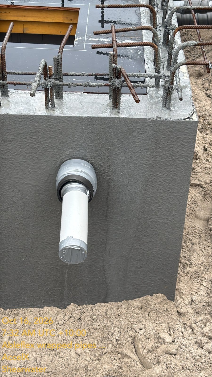 A pipe through the coated tank wall, with the epoxy fillet and membrane round it