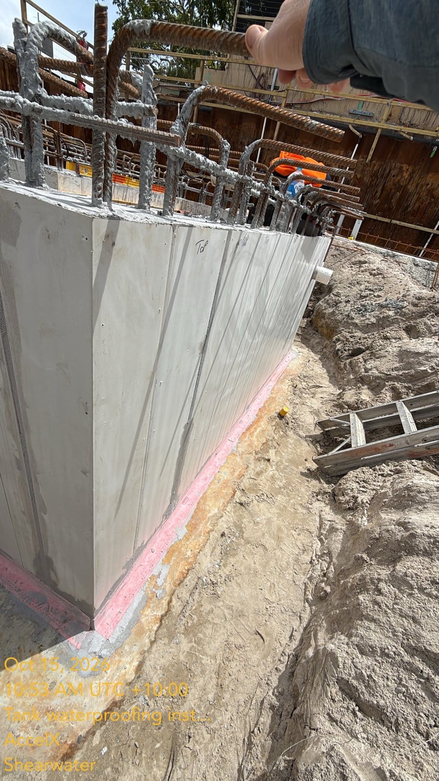 The floor-wall junction outside a tank wall, with the band bedded in epoxy before the membrane coats