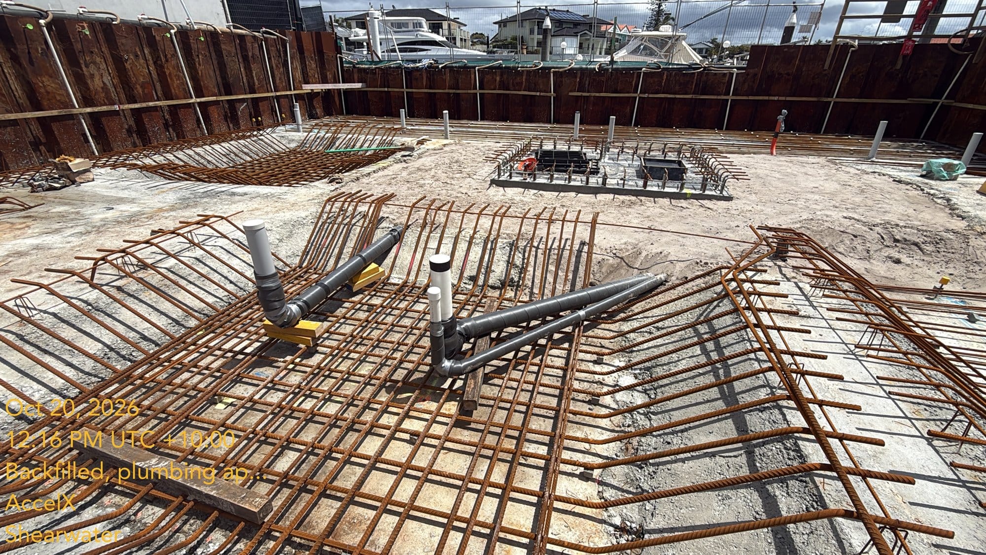 The tanks backfilled, with the lagged pipes waiting under the slab steel