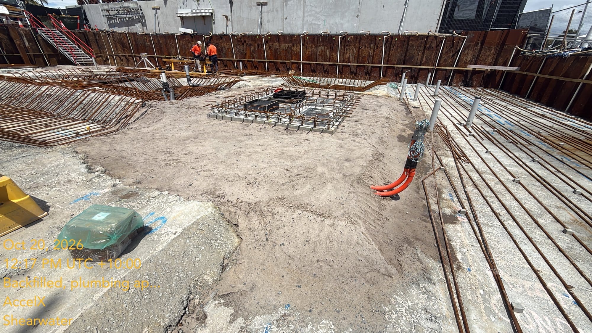 The bottom slab steel spreading across the finished blinding, around the tanks