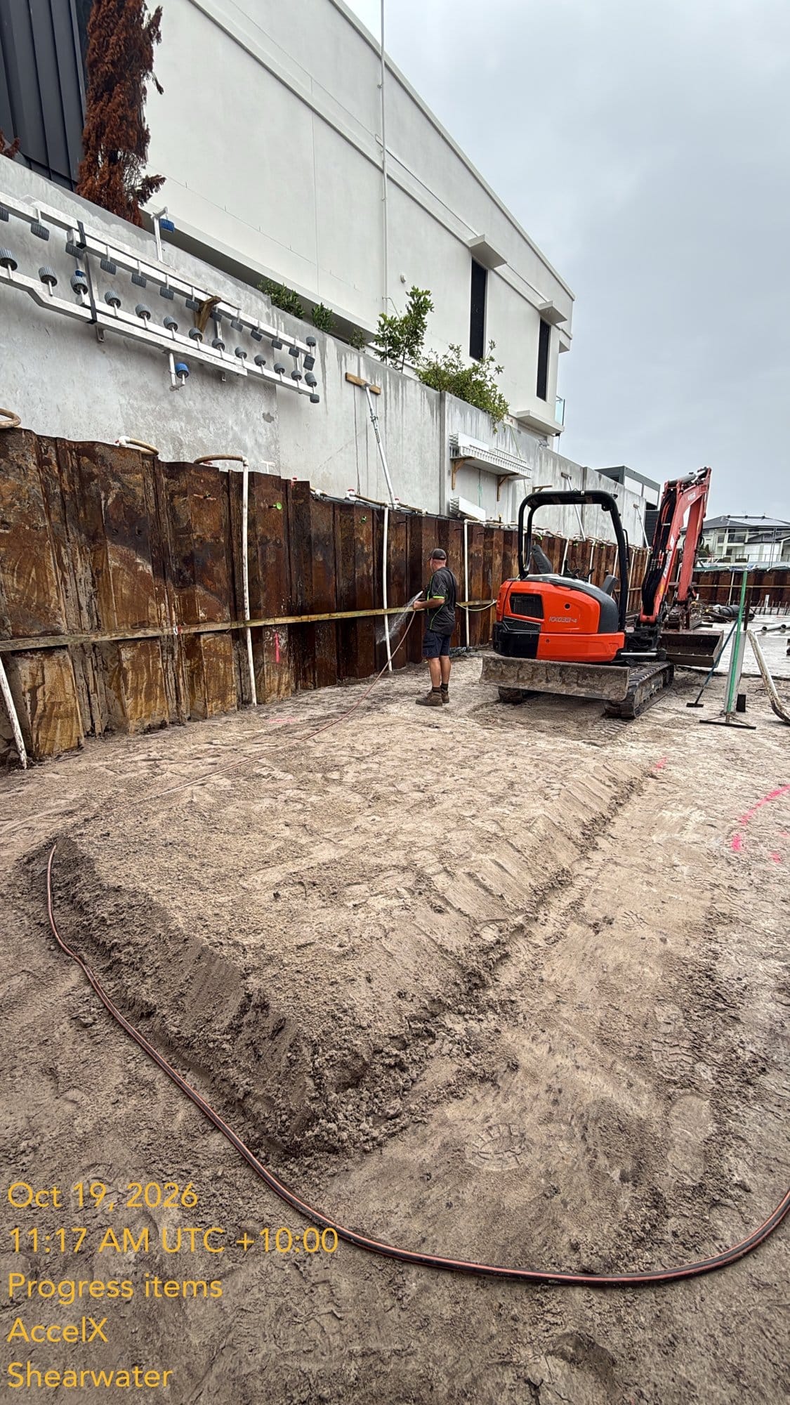 Hosing the sand off the sheet piles beside the shaped edge thickening