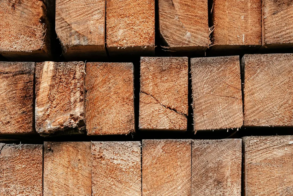 a close up of a pile of wood logs (stacked rectangular wooden beams)