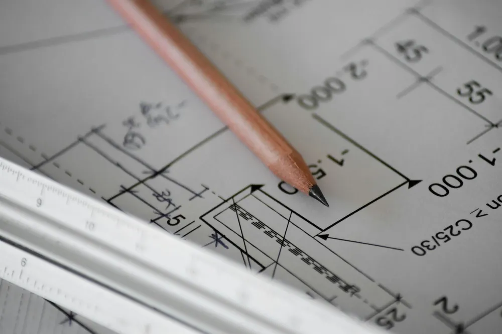 House plans and a pencil on a desk, ready for pricing
