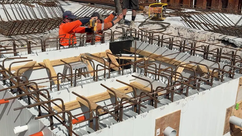 Concrete crew core filling the Rediwall tank walls from a boom pump hose