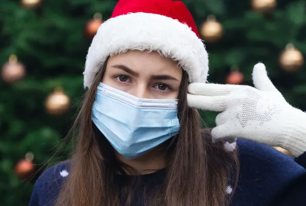 Lady wearing a mask and a Santa hat 