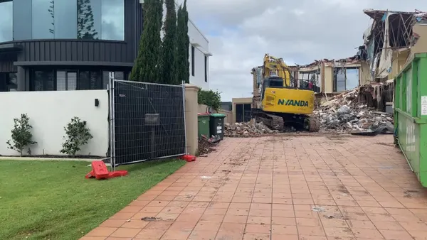25T excavator with grabber works away on the house demolition