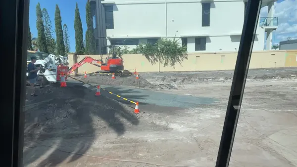 Compacting sand with a roller and skid steer to build a driveway ramp for quarry truck access