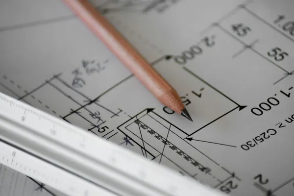 House plans and a pencil on a desk, ready for pricing