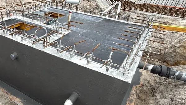 Stormwater and sewer tank coated in grey Sikalastic-1K membrane, with starter bars ready for the basement slab
