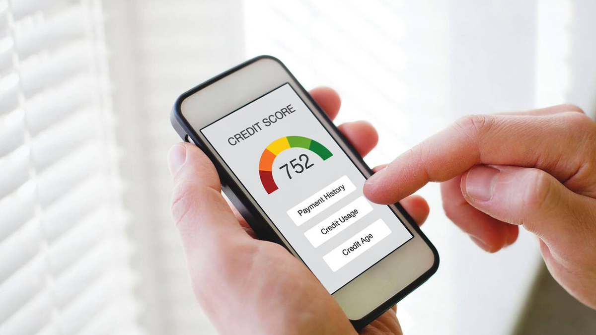 A person's hand scrolling through their credit report on phone.