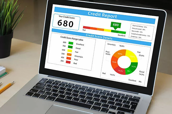 A credit report displayed on a laptop's screen with a credit score of 680