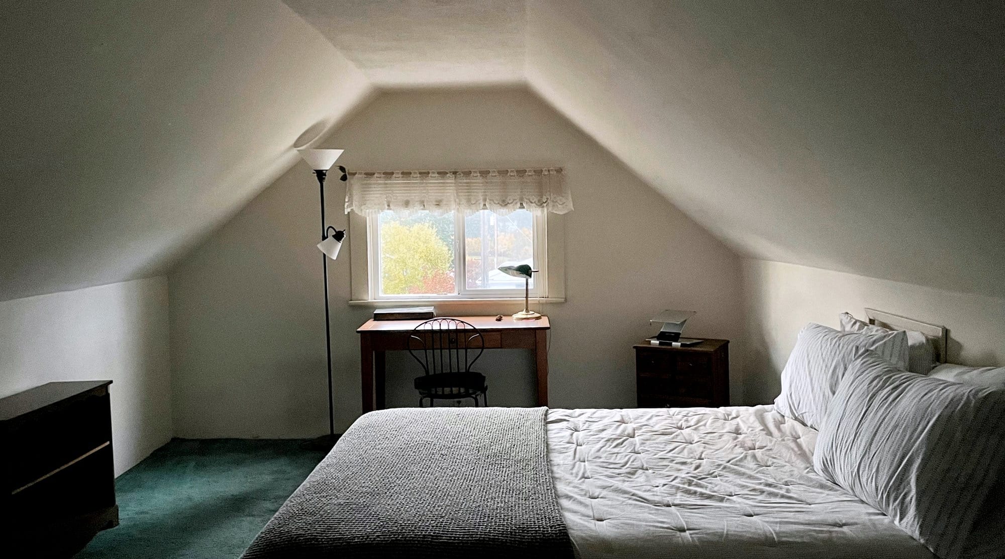 Attic bedroom with a bed and window