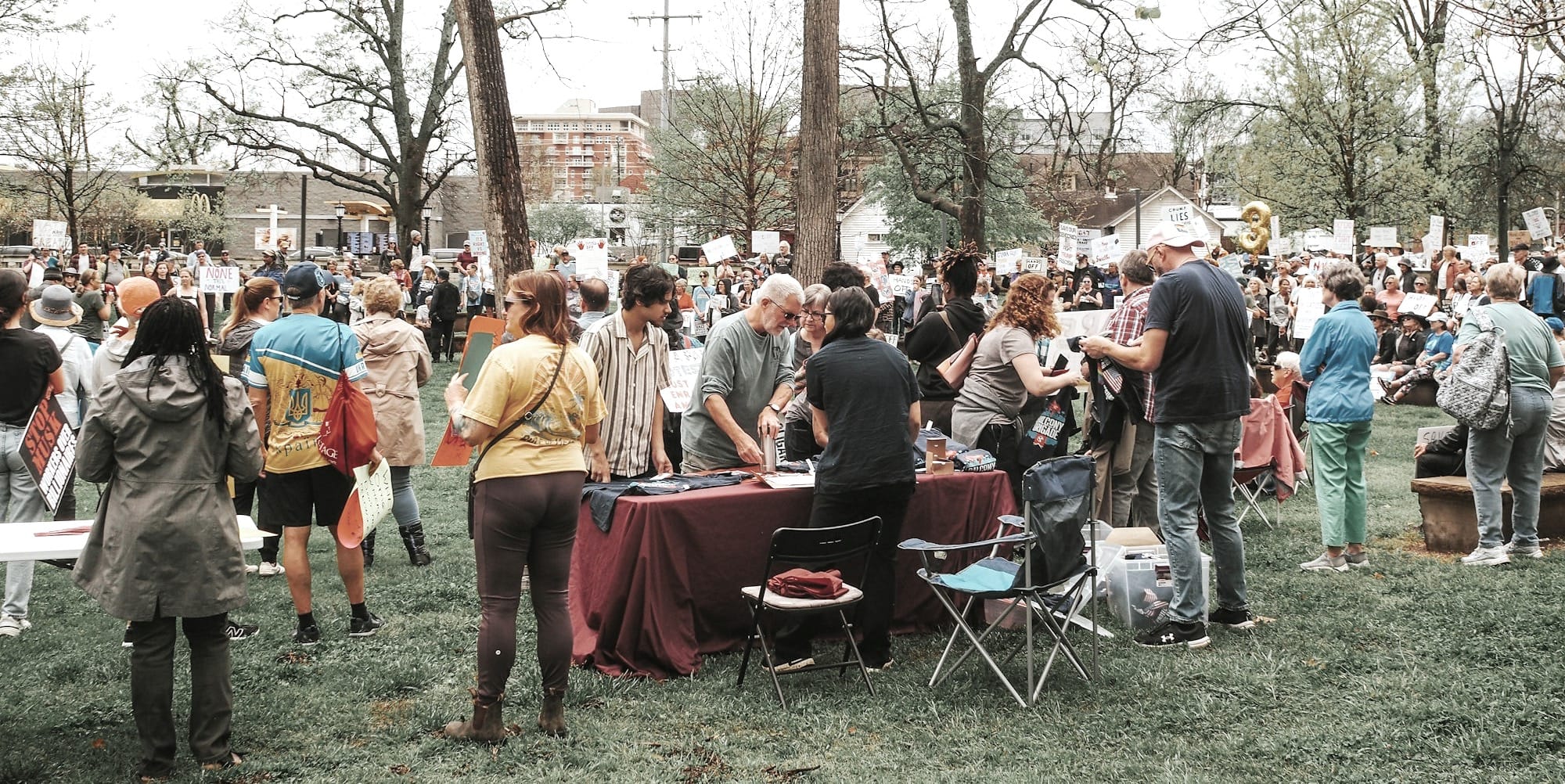People gather outdoors, possibly at an event.