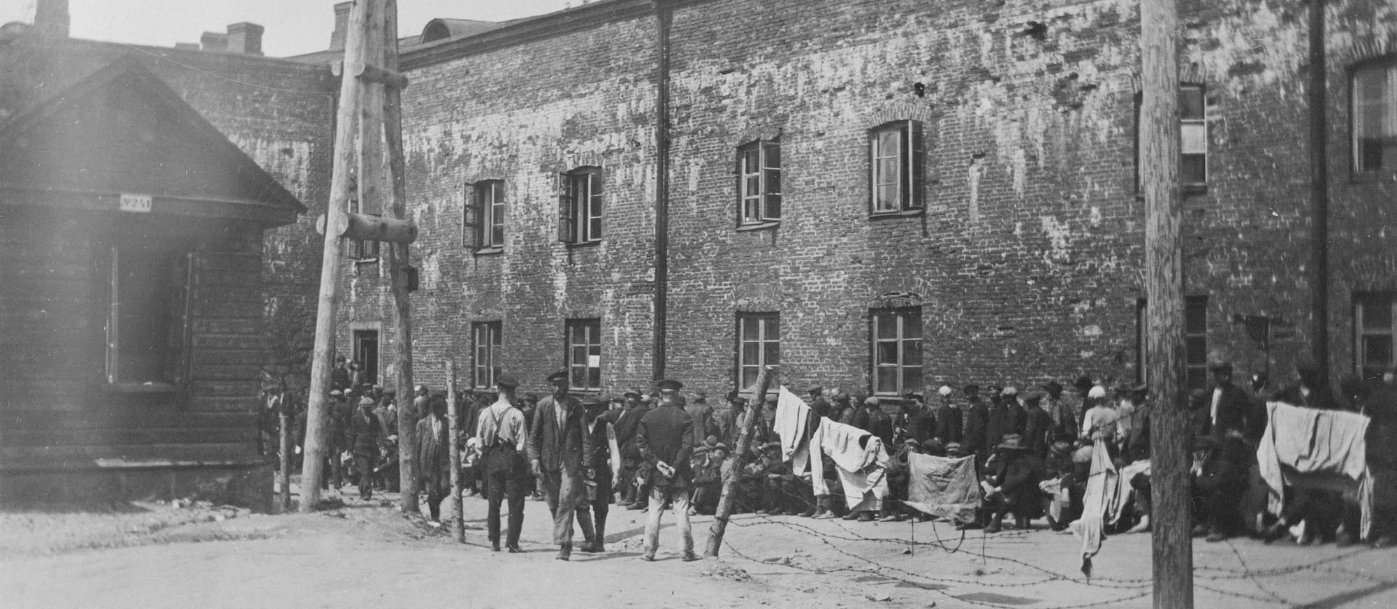 Group of people with flags in front of brick building