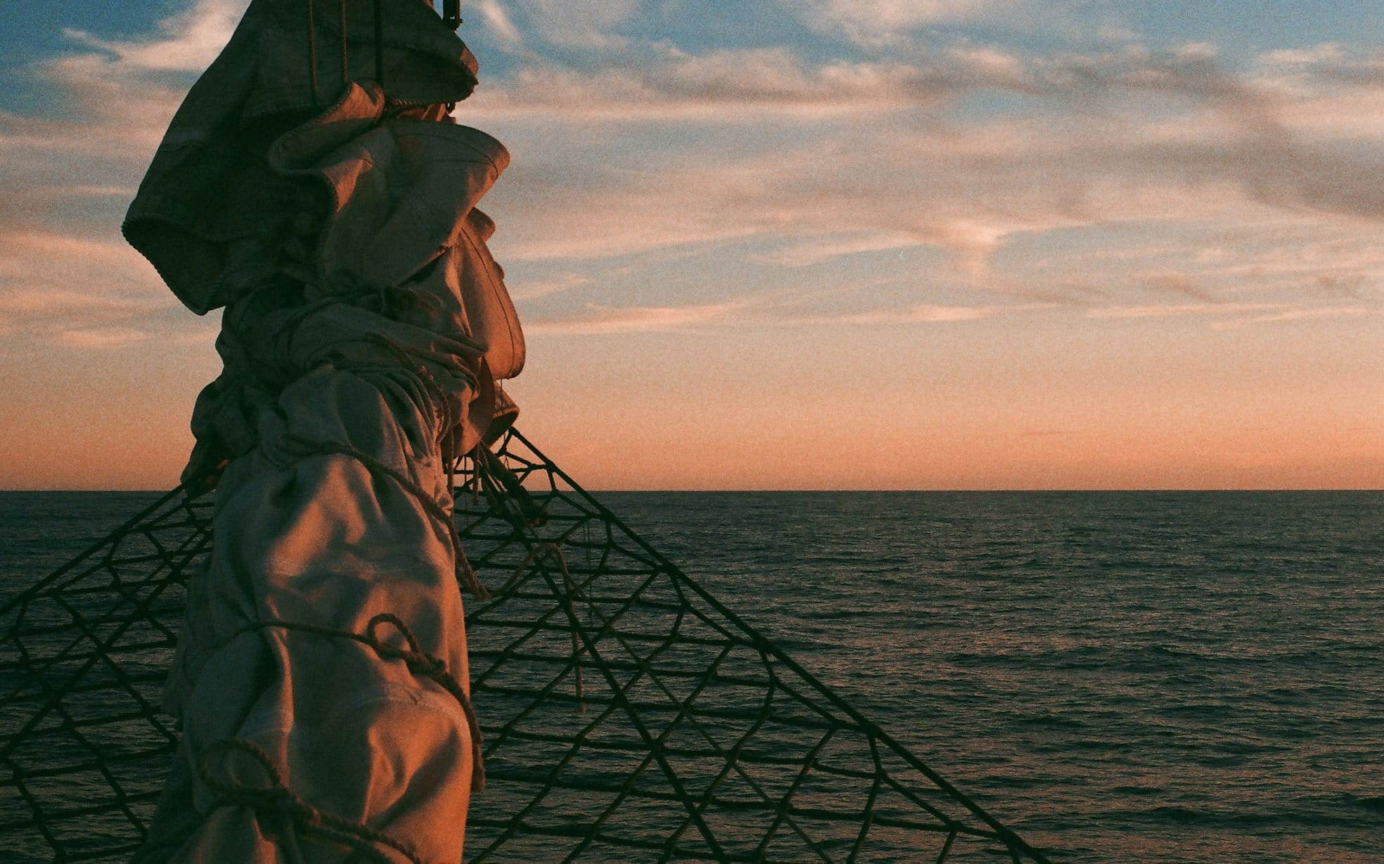 person in brown jacket and black cap standing on ship during daytime
