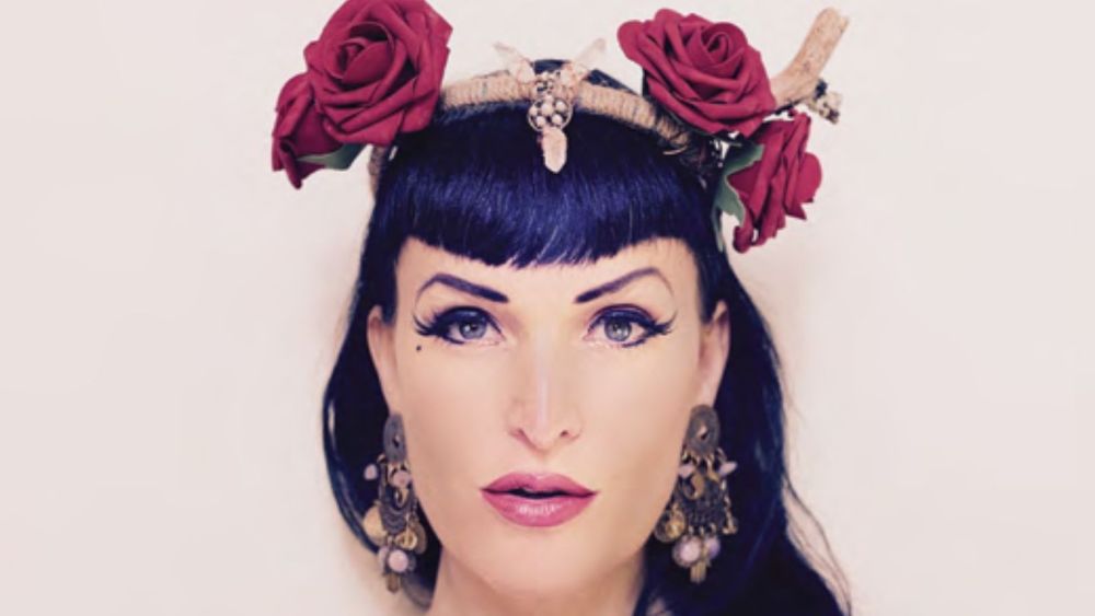 Woman with dark hair wearing a handmade crystal tiara with red roses in her hair.