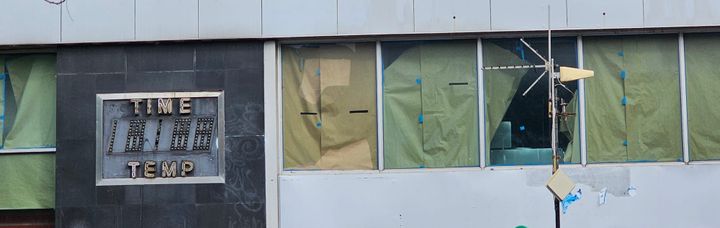 An NYC fossil: an old unused "time and temperature" sign beside empty office windows.