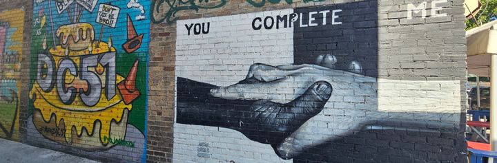 Two murals on a DC alley wall: DC51 / YOU COMPLETE ME 