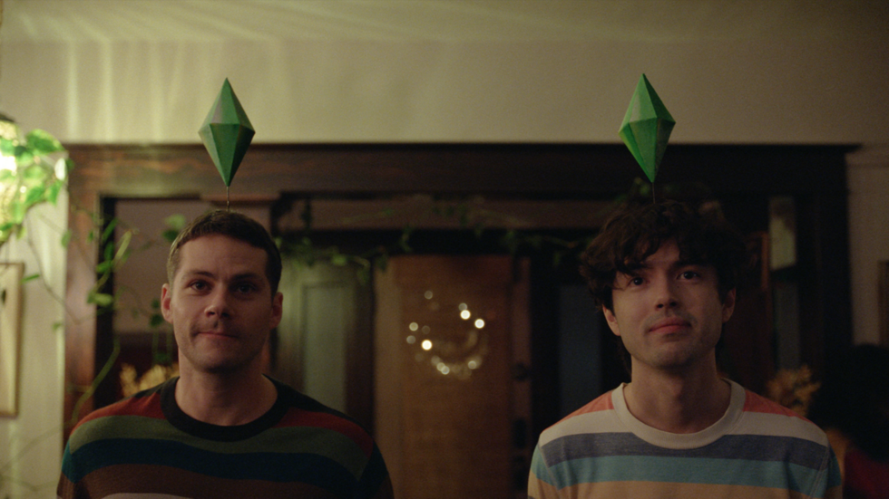 Two men in striped shirts with green Sims plumbob diamonds floating above their heads, standing in a dimly lit room.