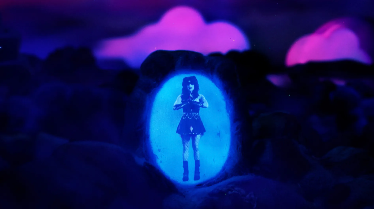 Silhouette of a woman in a short dress and boots glowing inside a blue oval portal, surrounded by dark rocks and pink clouds.