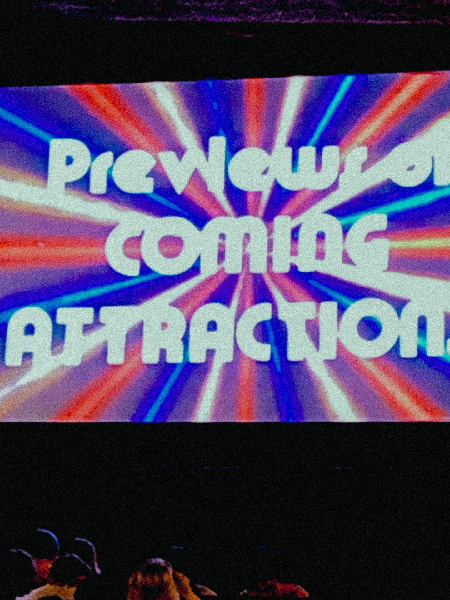 Retro movie theater screen displaying "Previews of Coming Attractions" in bold white text over colorful radiating stripes.
