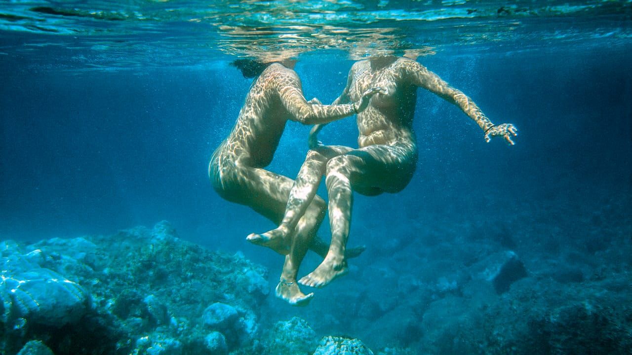 A woman swims underwater in a still from Lesvia.