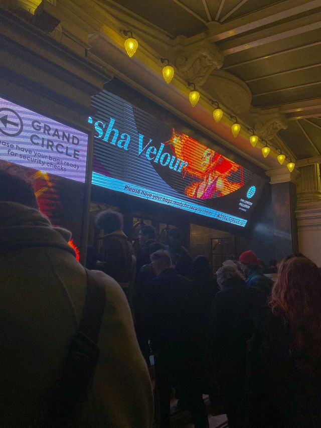 Crowd entering The London Palladium at night for a Sasha Velour show, with illuminated marquee and "Grand Circle" sign.