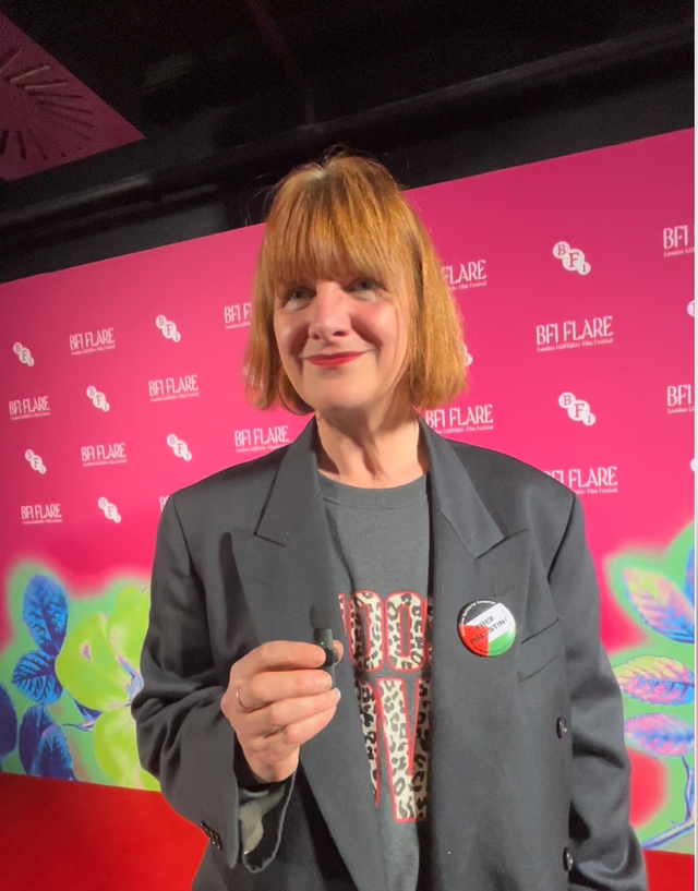 Person with red-blonde bob and bangs wearing a gray blazer with a "Free Palestine" pin, posing at a BFI Flare event.