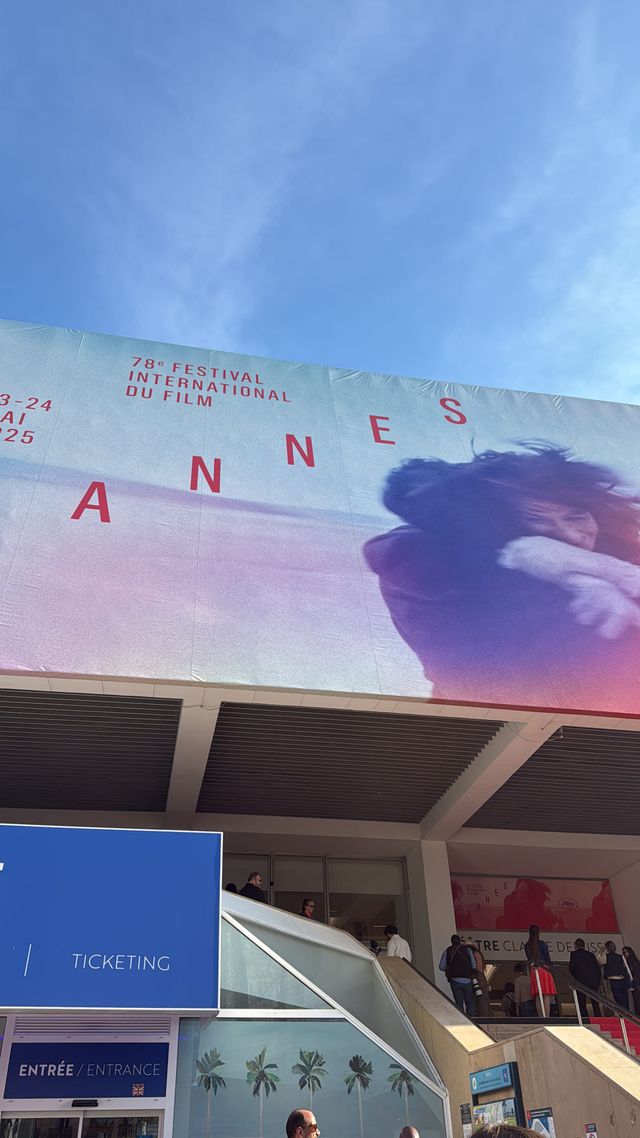 Large banner for 78th Cannes International Film Festival, May 13-24, 2025, on building facade with ticketing area below.