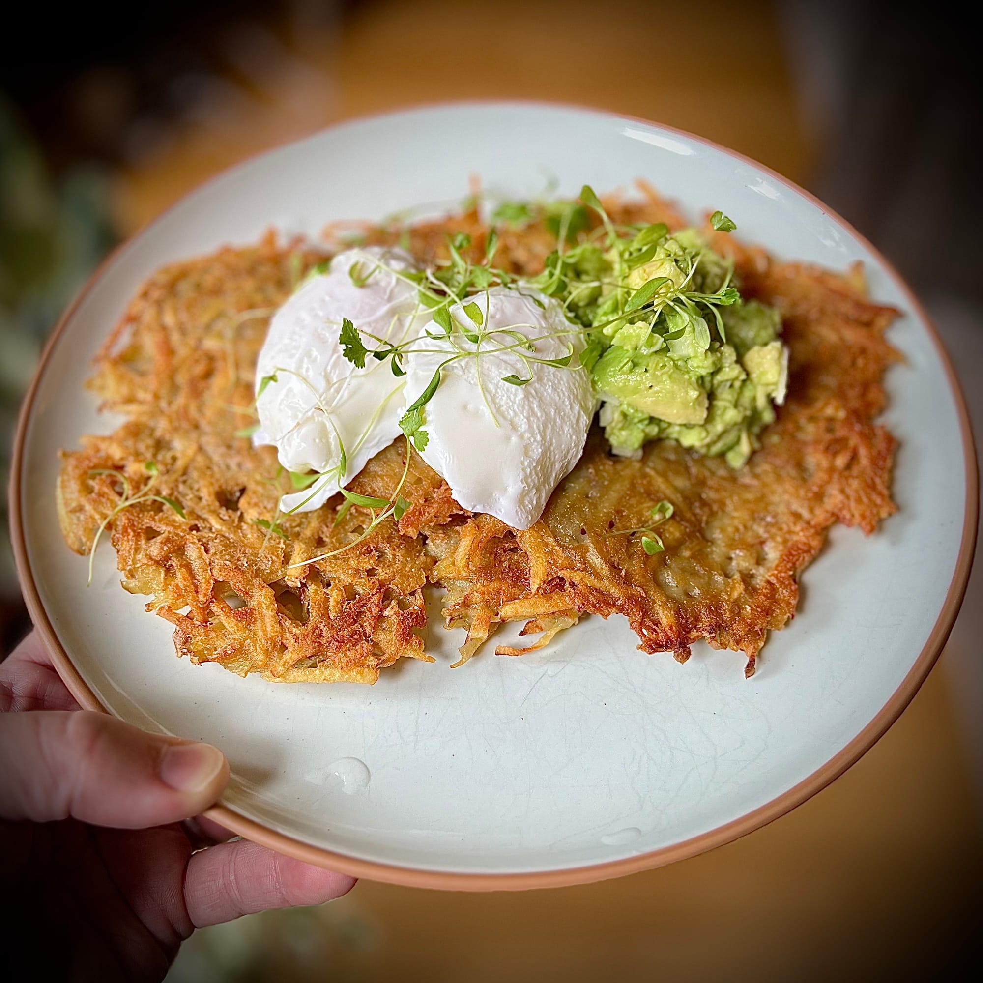 Perfectly Golden Potato Fritters with Poached Eggs, Guacamole, and Microgreens