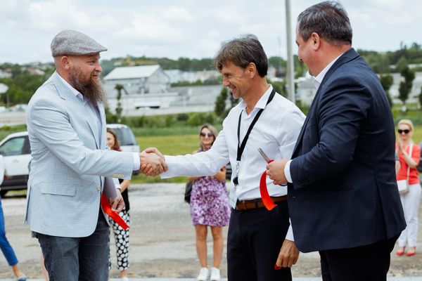Two Men Shaking Hands at a Ribbon-Cutting Ceremony