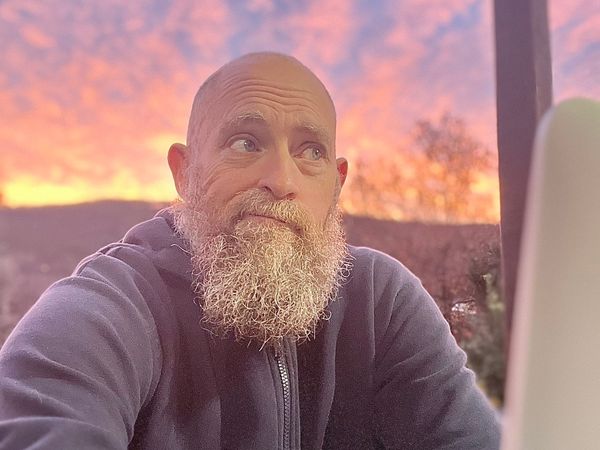 Man Looking Confused at Computer (With Sunrise in the Background)