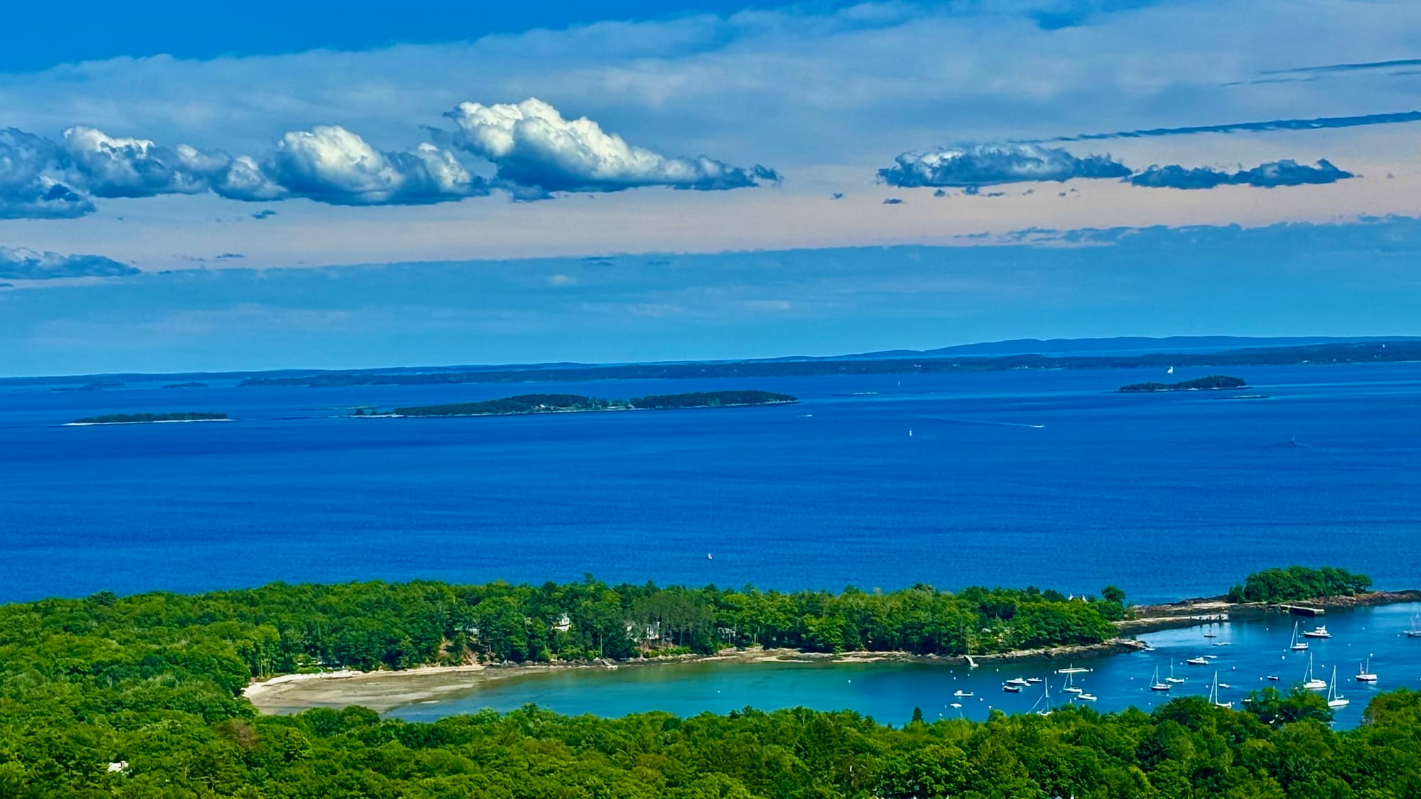 Expansive mountain view with lush greenery and a peaceful valley below, taken from a high vantage point on Mount Battie.