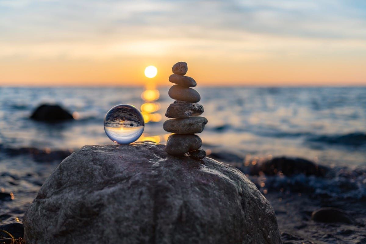 A peaceful sunrise over ocean rocks, symbolizing calm and steady progress in building daily habits and routines.