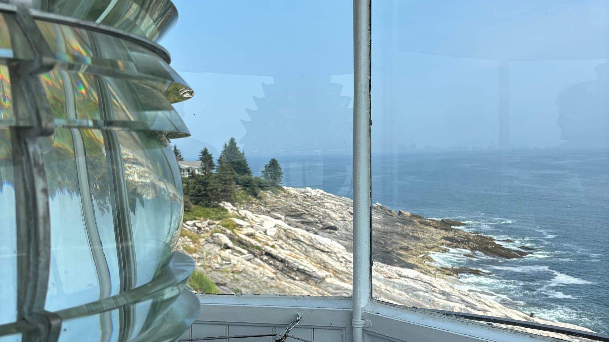 From the top of Pemaquid Point Lighthouse overlooking the ragged Maine Coastline with waves crashing.