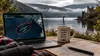 KI-Illustration von Loch Ness: Auf einem Laptop sind drei längliche Objekte in einer Satellitenansicht rot markiert. Daneben steht eine Tasse mit „Nessie works from home“; im Hintergrund ist 
