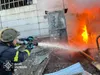 Feuerwehrmann löscht einen Brand am Wärmekraftwerk Trypilska in der Ukraine. Vor ihm schlagen hohe Flammen aus einer beschädigten Anlage.