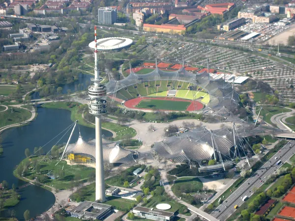 Luftbild des Münchner Olympiaparks mit Olympiaturm, Olympiastadion unter dem Zeltdach und Olympiasee
