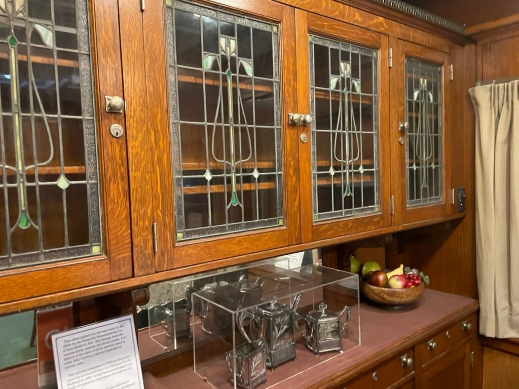 deep wood cupboards with stained-glass in a cross pattern inset into each door